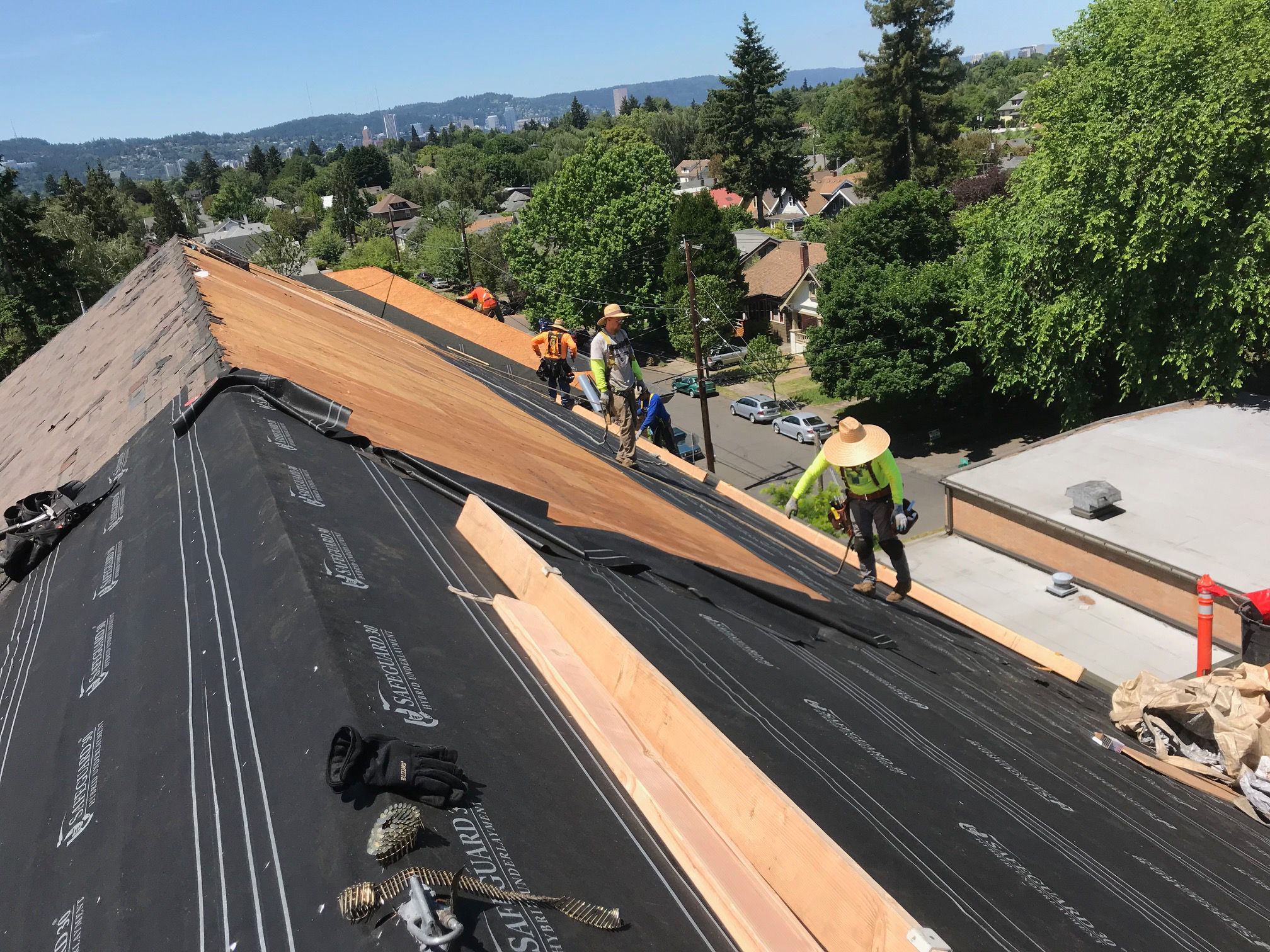 how to choose a roofing contractor. Image of men on a roof replacing it.